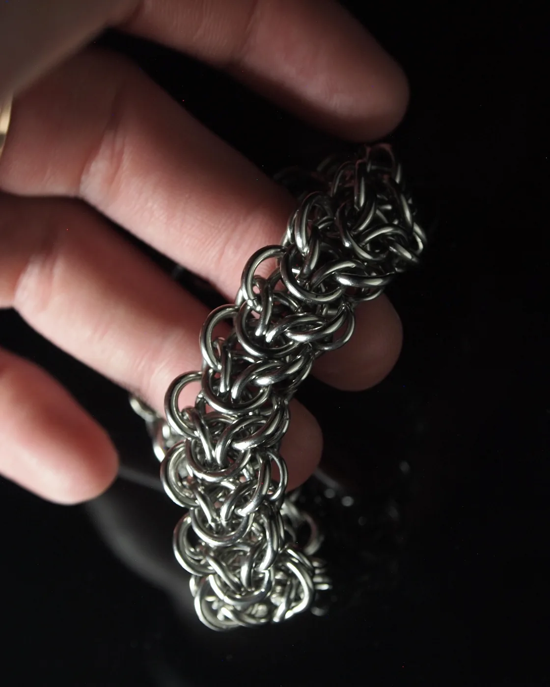 Close-up of stainless steel chainmail held by hand